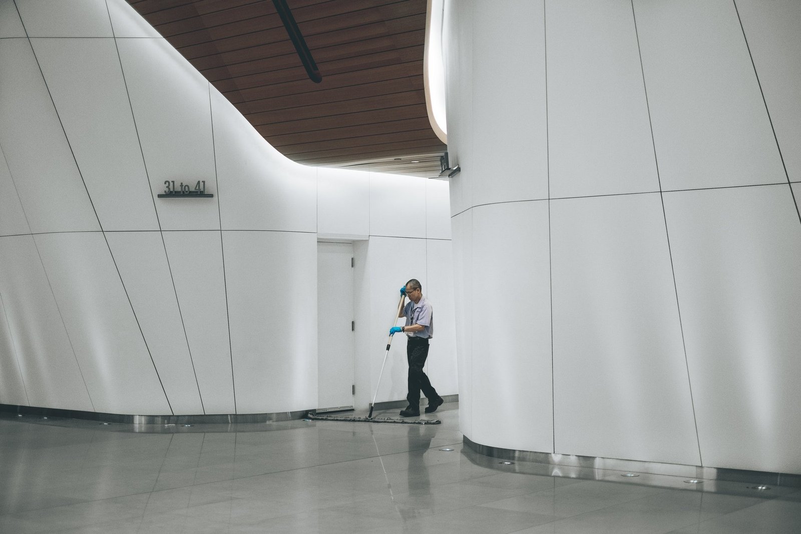 Professional cleaner maintaining a bright commercial hallway